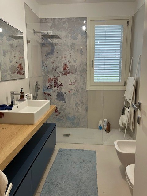 bagno con rivestimento effetto marmo chiaro