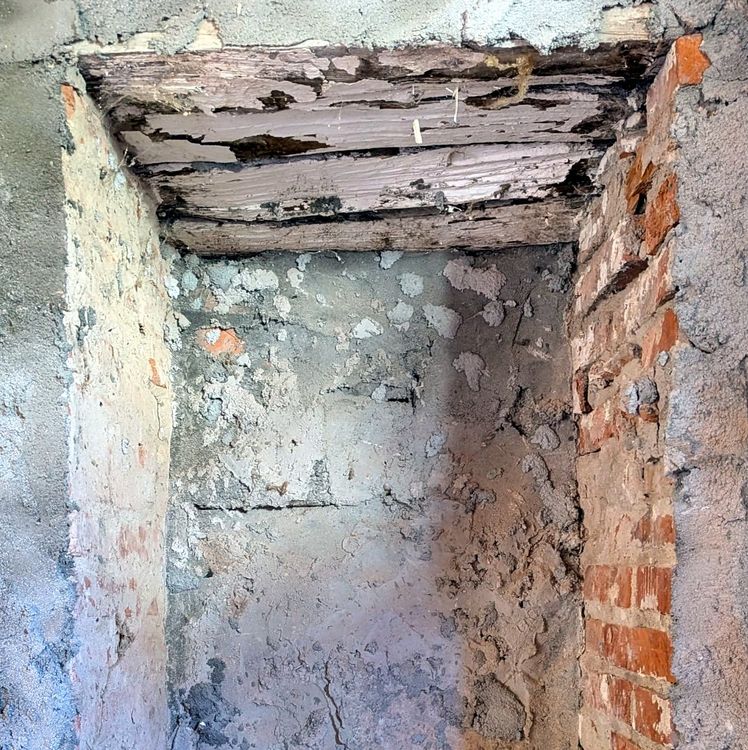 angolo di un muro in pietra e mattoni con intonaco scrostato dal tempo